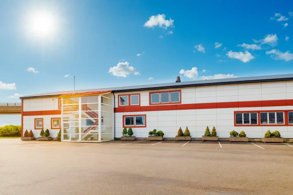 Bilde av lokalene utvendig til autoAC AS på Lierstranda i utkanten av Drammen, sentralt ved E18, Brakerøya jernbanestasjon, Drammen sykehus og CC-Vest, sol og blå himmel i september 2025